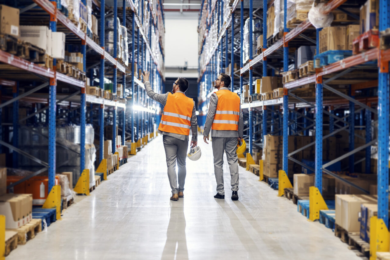 Two businessmen walking around storage.